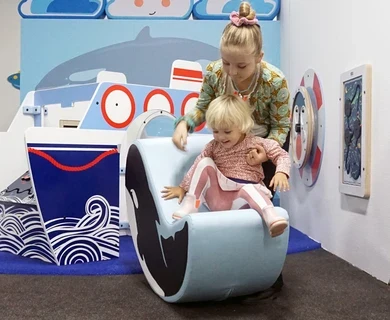 Wandspeelbord en softplay kussen om mee te spelen in een kinderhoek in de wachtruimte