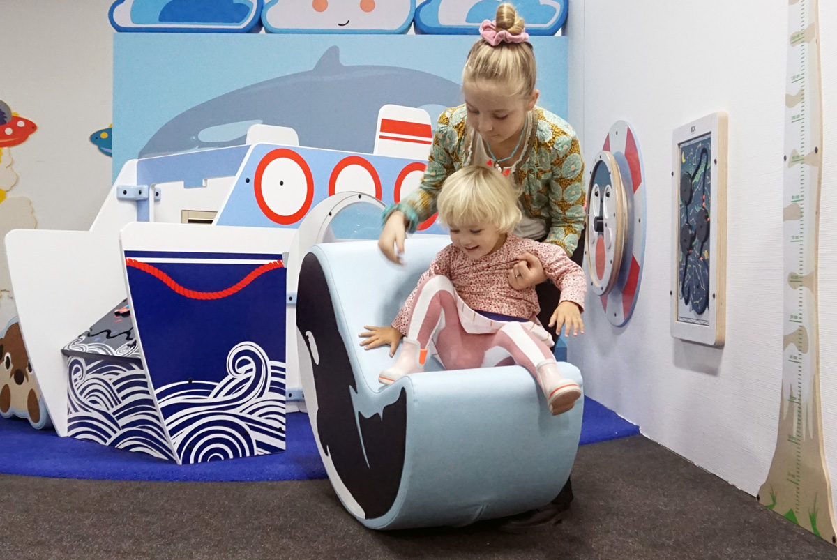 Wandspeelbord en softplay kussen om mee te spelen in een kinderhoek in de wachtruimte