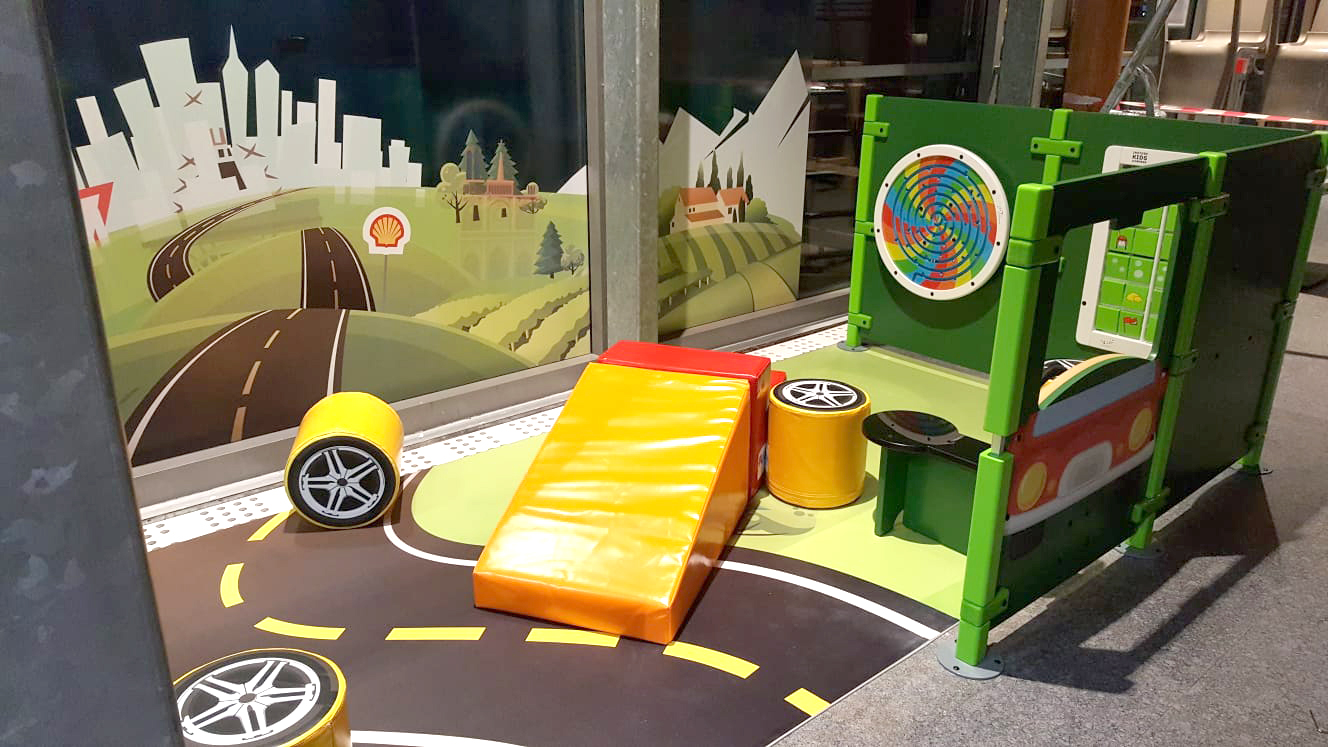 Children's play corner at Shell petrol station in France with various play modules and wall games