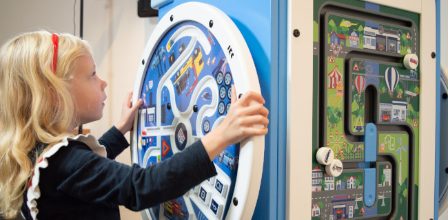 children playing wall game board rotating educational