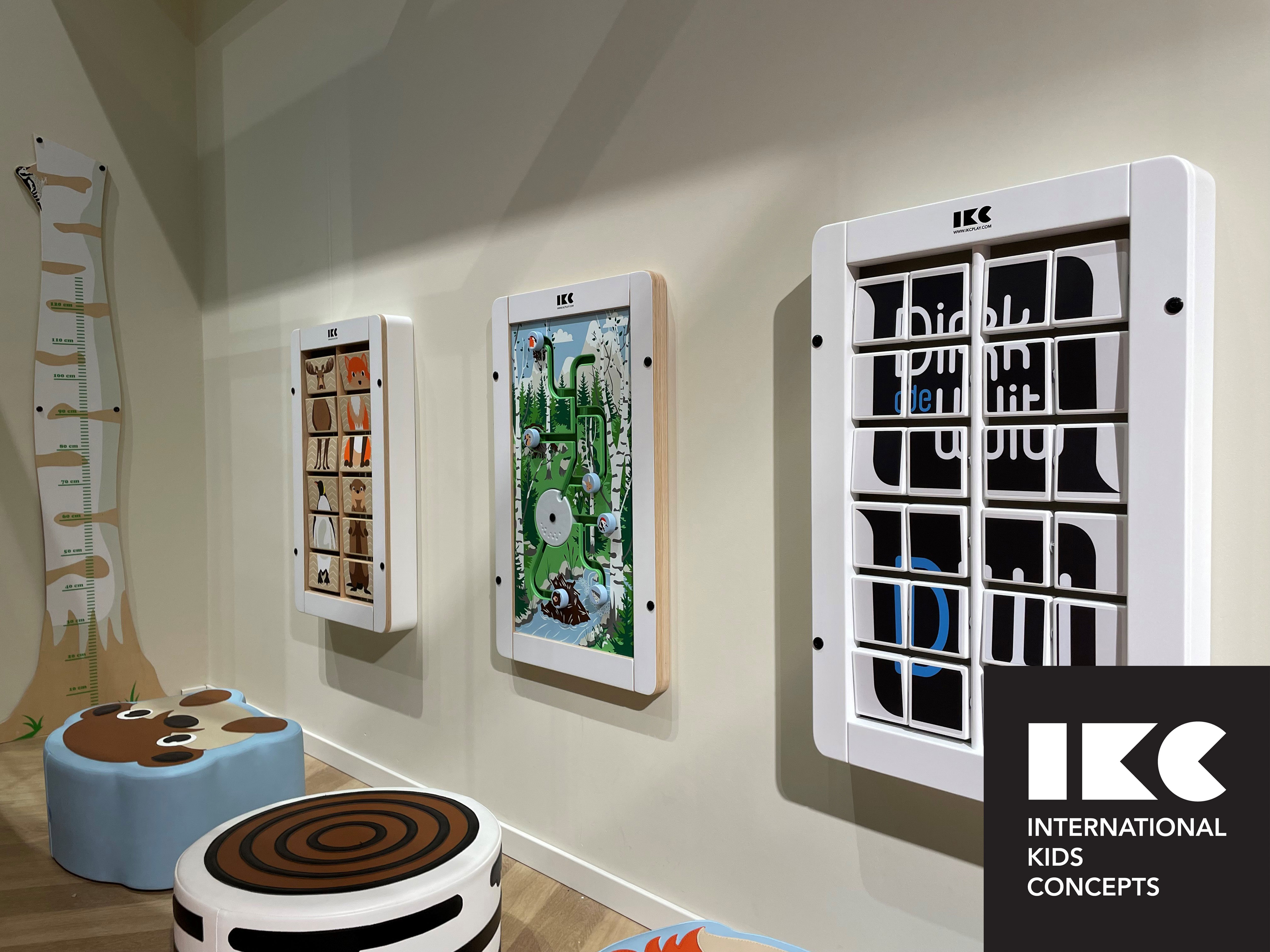 Soft-Play Kids' Corner with Wall-Mounted Games – IKC Concept Children’s corner with interactive wall play panels and soft seating in a public waiting area