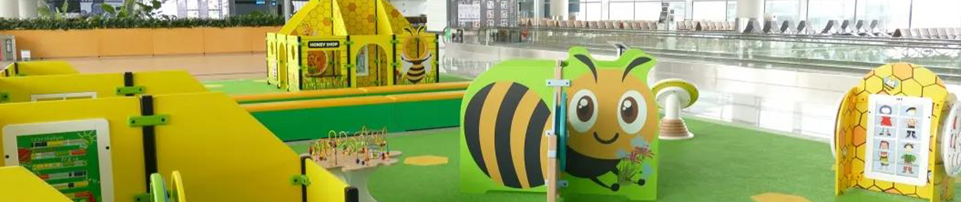 Kinderhoek in openbare ruimte – Bijenthema speelconcept Speelhoek in een openbare ruimte met een bijenthema, inclusief speelhuis, interactieve speelwanden en klim- en klauterelementen, ontworpen door IKC.